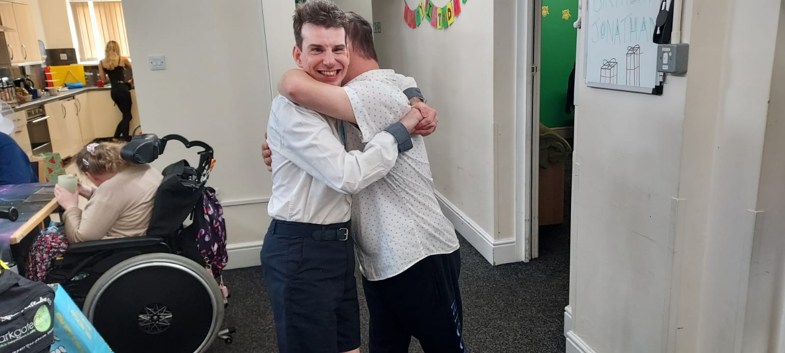 Friends sharing a warm hug at Edmund Street Activity Centre